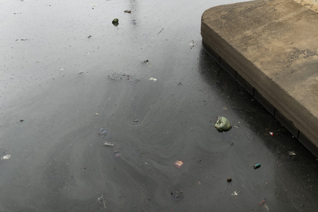 Pollution and waste seen floating on the surface of the river.
