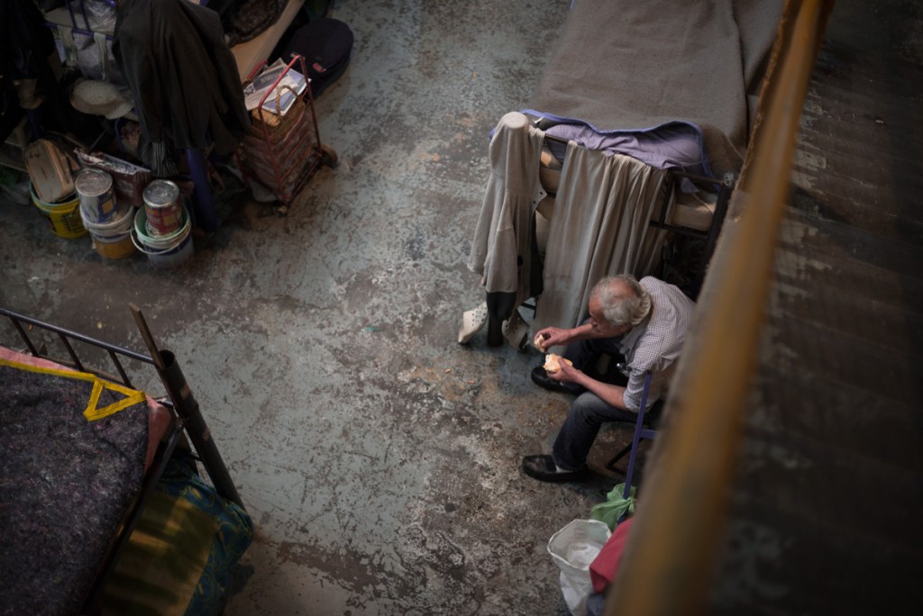 Man eating bread inside one of the dormitory rooms.